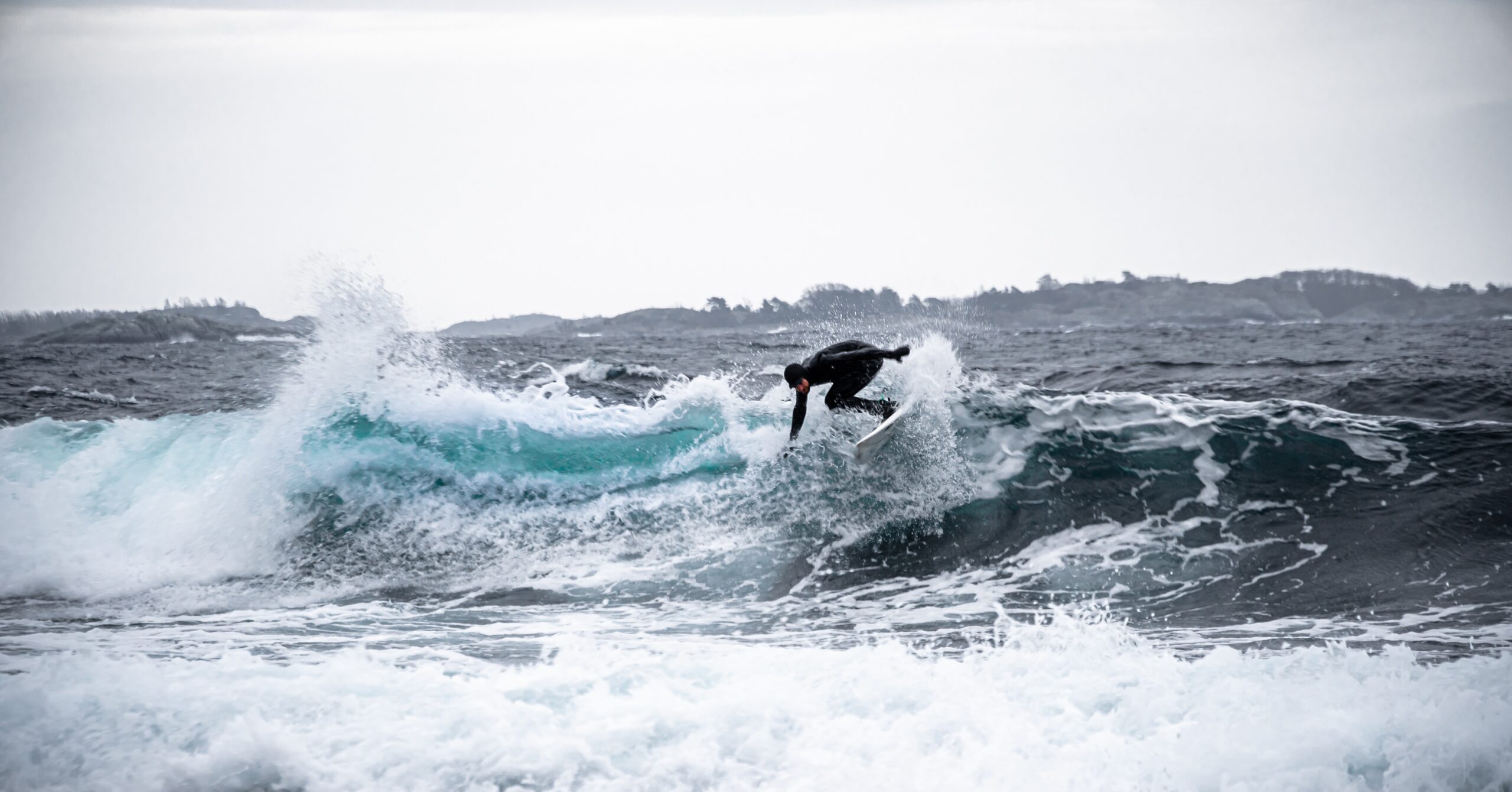 a surfer riding a wave in the winter scaled