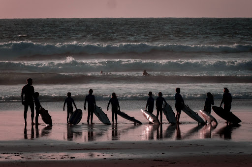 People standing with surfboards on a beach